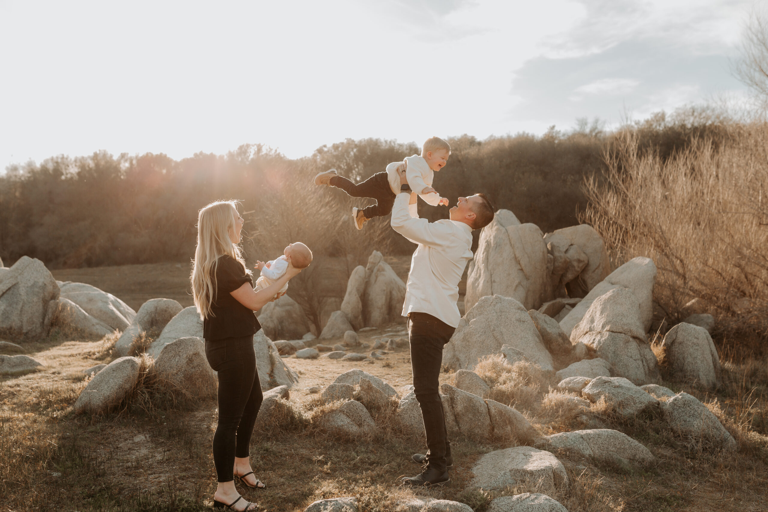 family with baby and toddler at sunset with boulders